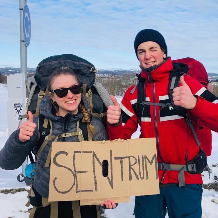 To elever med tommelen opp og et skilt der det står "sentrum"