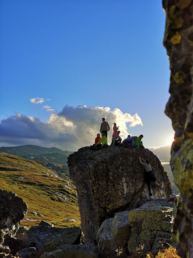 Mennesker på toppen av en stor stein i norsk natur