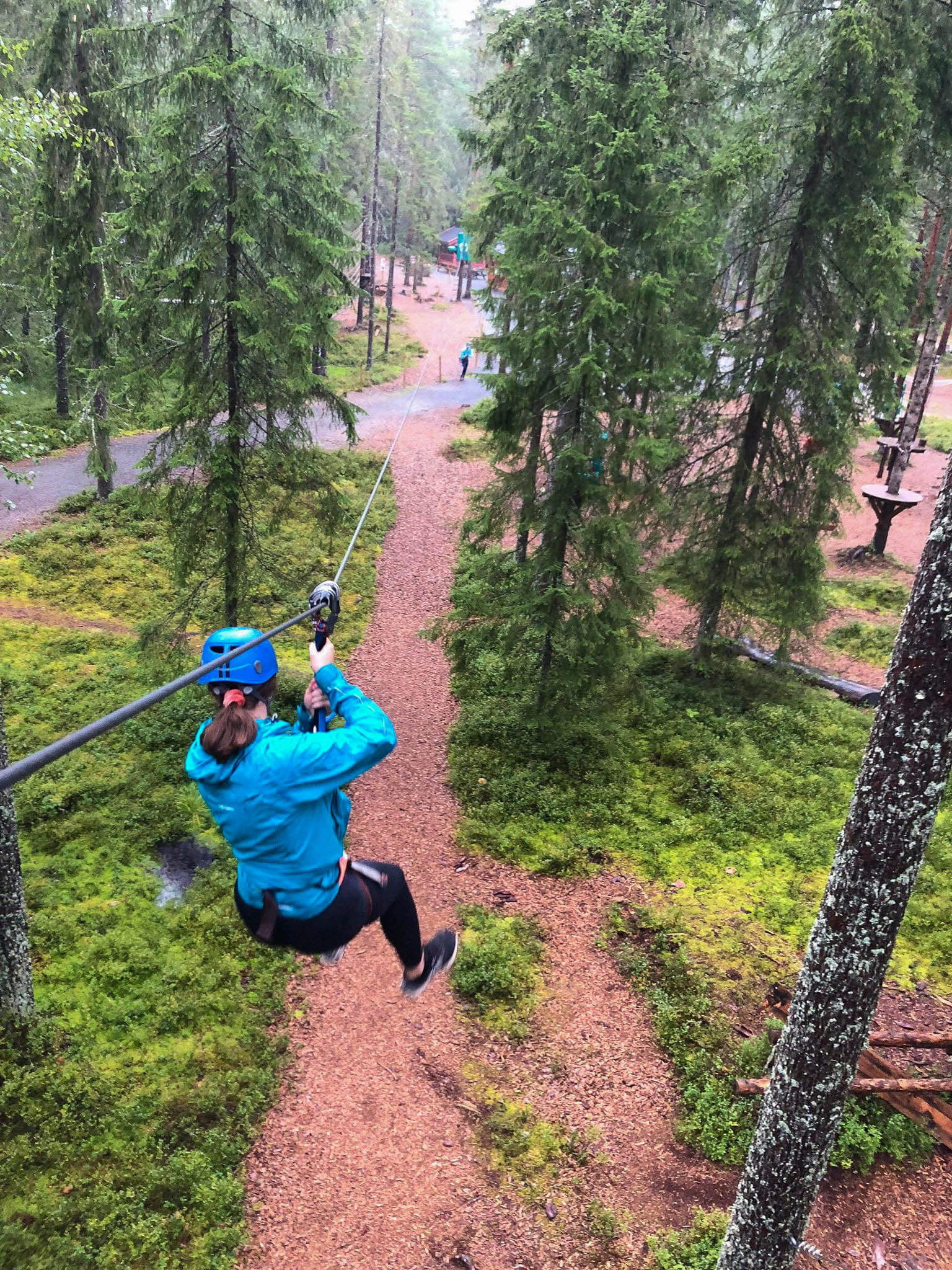 Kvinne på vei gjennom skogen på zipline