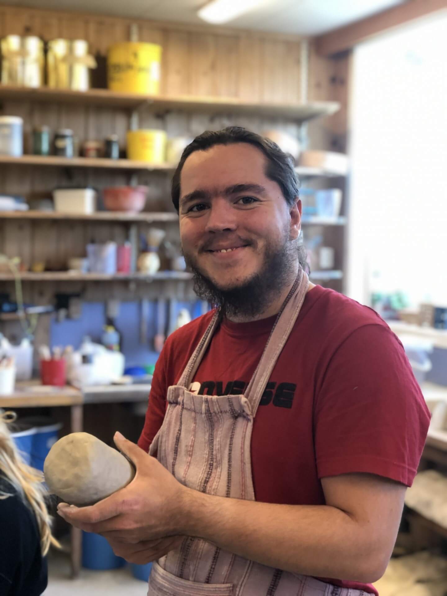Mann smiler på keramikk-verkstedet