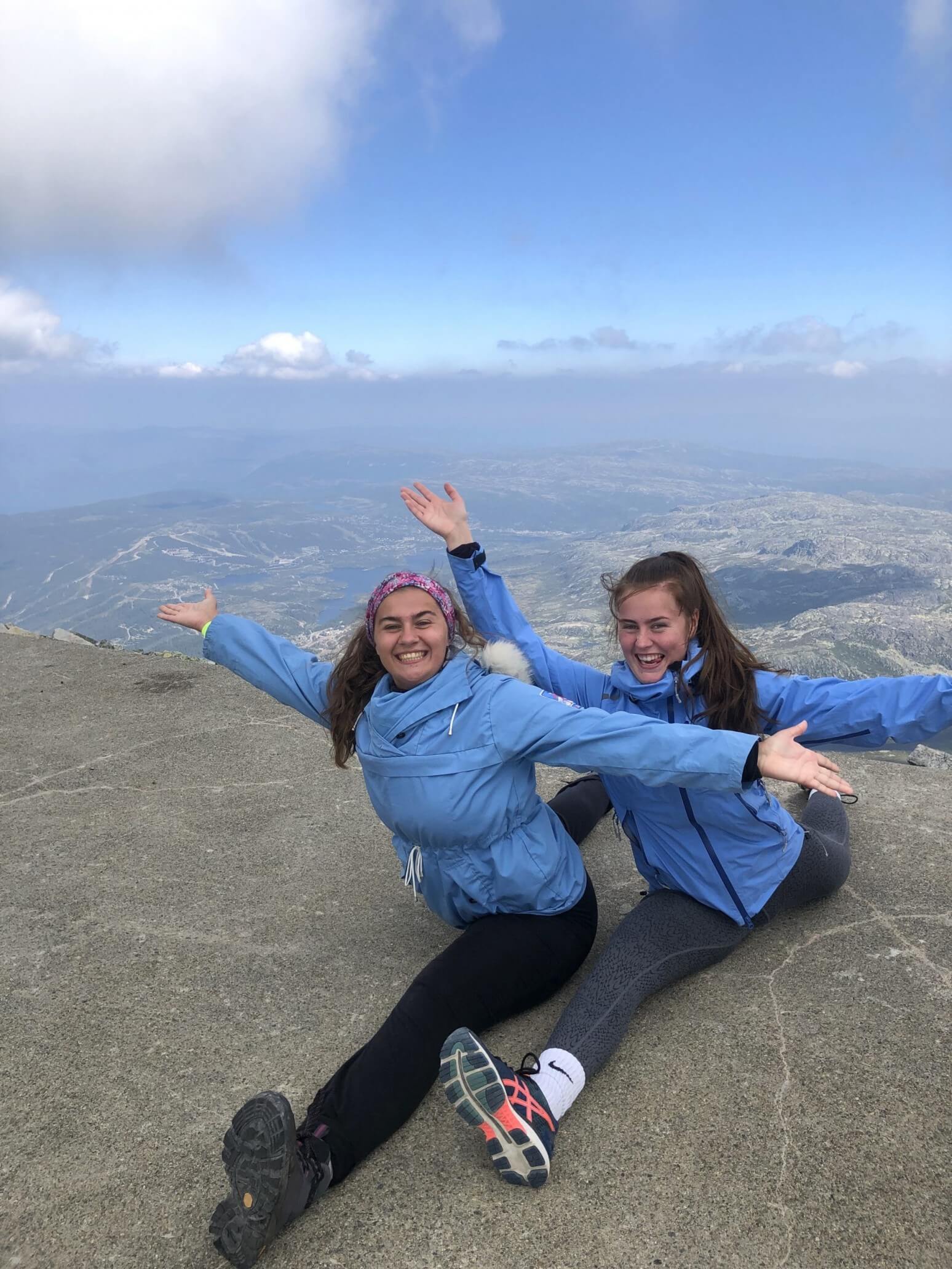 To kvinner i spagaten på en fjelltopp