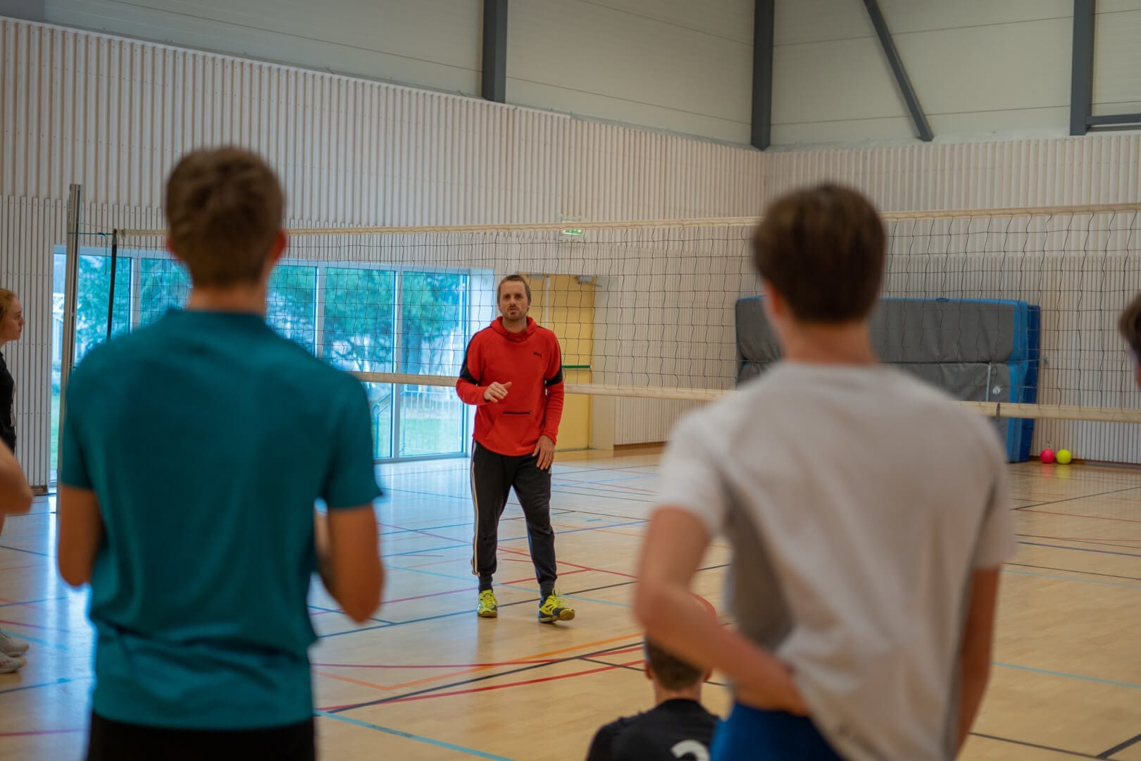 Elever og lærer ved volleyballnett