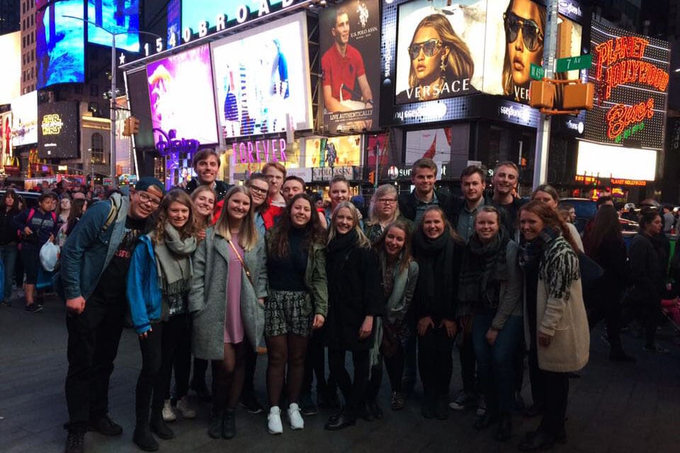 Elever i New York foran reklame på gaten