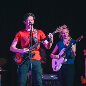 Band To elever som spiller gitar og synger på scene